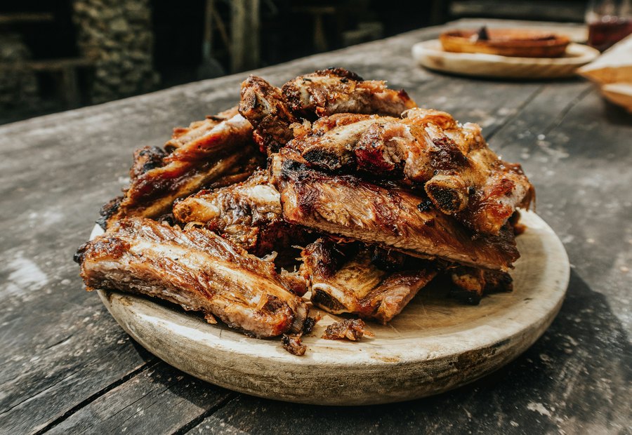 Grilled ribs served on a wooden board.